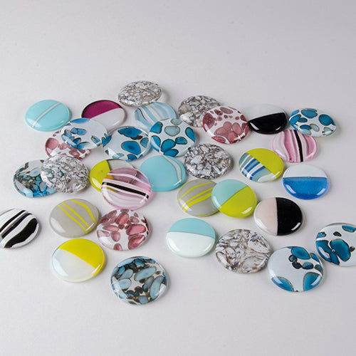 Collection of colorful glass cabochons on a white background