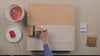 An overhead video of shelf primer being applied to a kiln shelf with a wide brush