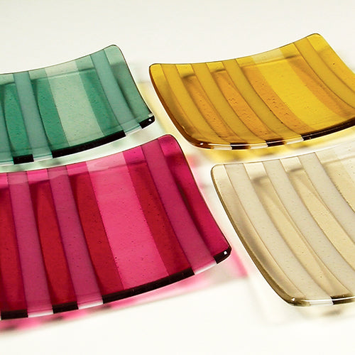 Four colorful glass plates on a white background